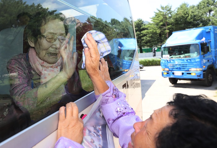 Am 22. August, dem letzten Tag des 21. innerkoreanischen Familientreffens, berührt die Tochter von Han Shin-ja weinend das Busfenster, um die Hand ihrer Mutter zu spüren.