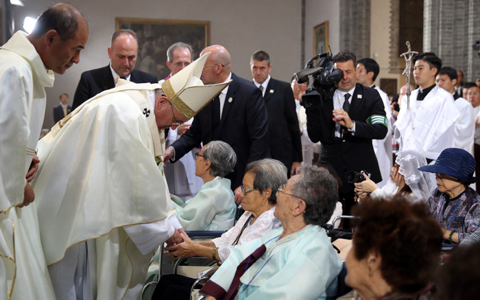 프란치스코 교황이 18일 명동성당에서 열린 '평화와 화해를 위한 미사'에 참석한 위안부 피해 할머니들의 손을 잡아주며 축복하고 있다. (사진: 연합뉴스)