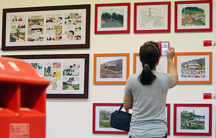 서울국제만화애니메이션 페스티벌 (SICAF 2014) 개막식'에서 한 관람객이 전시된 만화 작품을 감상하고 있다. (사진: 전한)