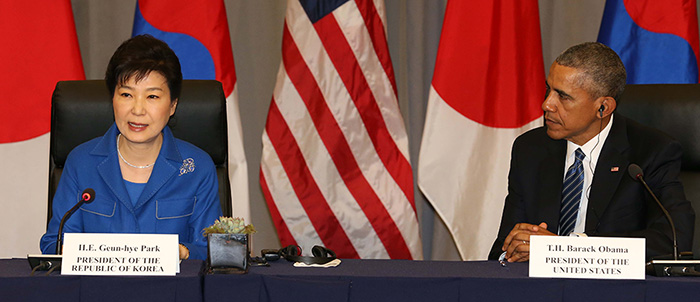 President Barack Obama (right) listens to President Park Geun-hye during the trilateral summit in Washington.