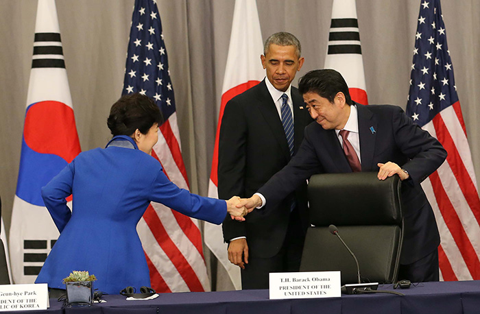 President Park Geun-hye shakes hands with Prime Minister Shinzo Abe during the trilateral summit among Korea, the U.S. and Japan.