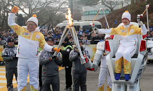 Roboter tragen die olympische Flamme für PyeongChang 2018