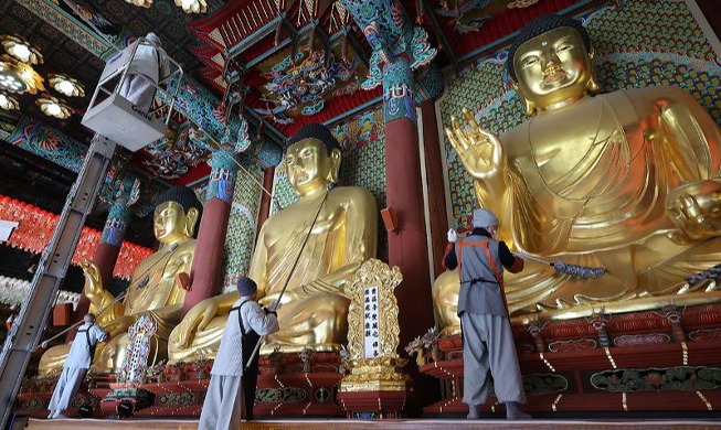 Staub von der Buddhastatue putzen