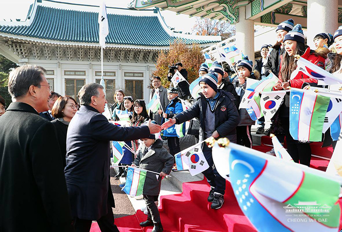 문재인 대통령과 샤브카트 미르지요예프 우즈베키스탄 대통령이 23일 청와대 공식환영식에서 양국 어린이들과 인사를 나누고 있다.