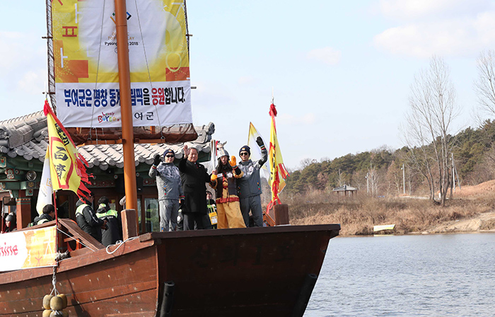 5일 충청남도 부여에 도착한 성화를 백제 장군복을 입은 주자가 황포돛배에 올라 봉송하고 있다.