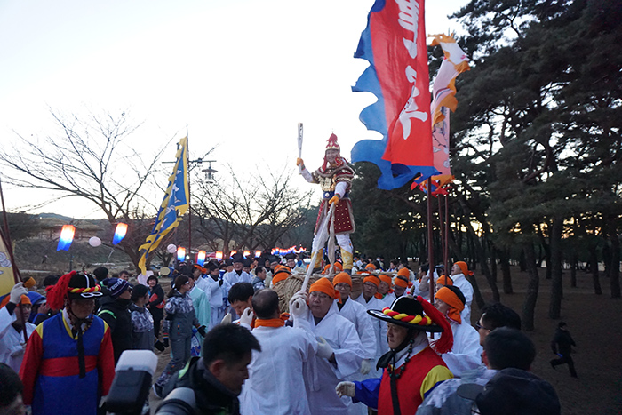 '2018 평창 동계올림픽' 성화 봉송 주자가 지난 12월 26일 경상북도 안동 하회마을에서 차전놀이 동채를 타고 이동하고 있다. 연합뉴스