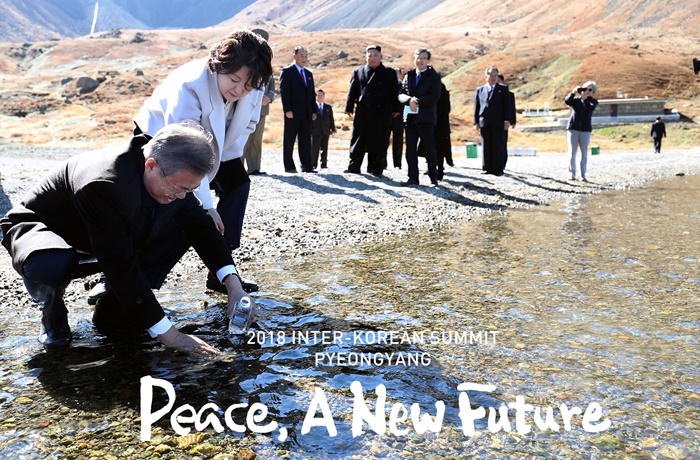 Der südkoreanische Präsident Moon Jae-in füllt am 20. September 2018 eine Plastikflasche mit Wasser aus dem Cheonji-See am nordkoreanischen Berg Baekdu.