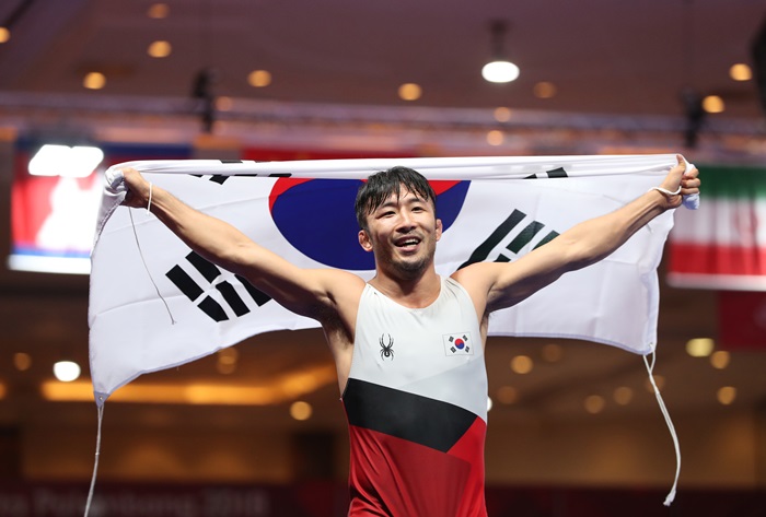 Der südkoreanische Ringer Ryu Hansu hält die Taegeukgi-Nationalflagge hoch, nachdem er am 21. August im Jakarta Convention Center (JCC) in der indonesischen Hauptstadt die Goldmedaille im griechisch-römischen 67-kg-Finale der Männer gewonnen hatte. ⓒ Yonhap News