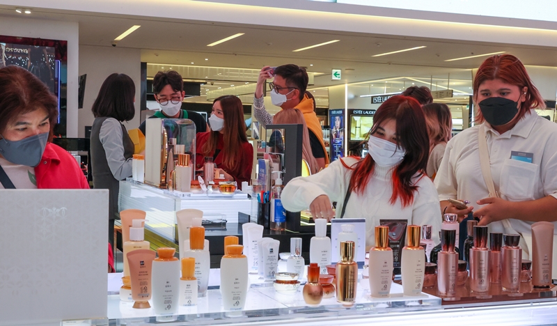 Südkorea wird die visumfreie Einreise für internationale Reisende ab nächsten Monat wieder aufnehmen. Abgebildet sind thailändische Touristen, die am 15. April 2022 in einem Duty-Free-Shop des Einzelhandelsgiganten Shinsegae koreanische Kosmetik sehen. ⓒ Yonhap News