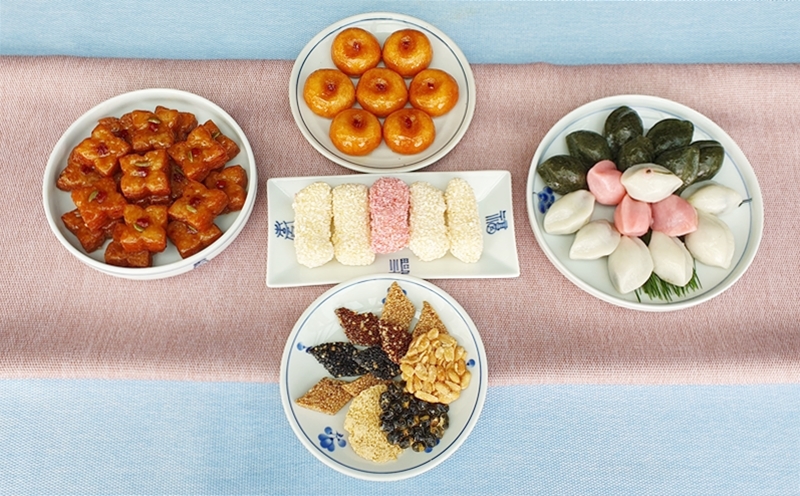 Das Teegebäck für Chuseok. Von links im Uhrzeigersinn gibt es Moyakgwa (quadratische frittierte Honigplätzchen), Gaeseong-Umegi (Klebreis-Mehl-Reiskuchen), Songpyeon (mit gemahlenen Sesamkörnern oder Sirup gefüllten Reiskuchen) und Gangjeong (gebratene klebrige Nuss-Cracker). Es gibt auch Yugwa (frittierte Reisbällchen) in der Mitte davon. ⓒ Lee Kyoung Mi/korea.net 