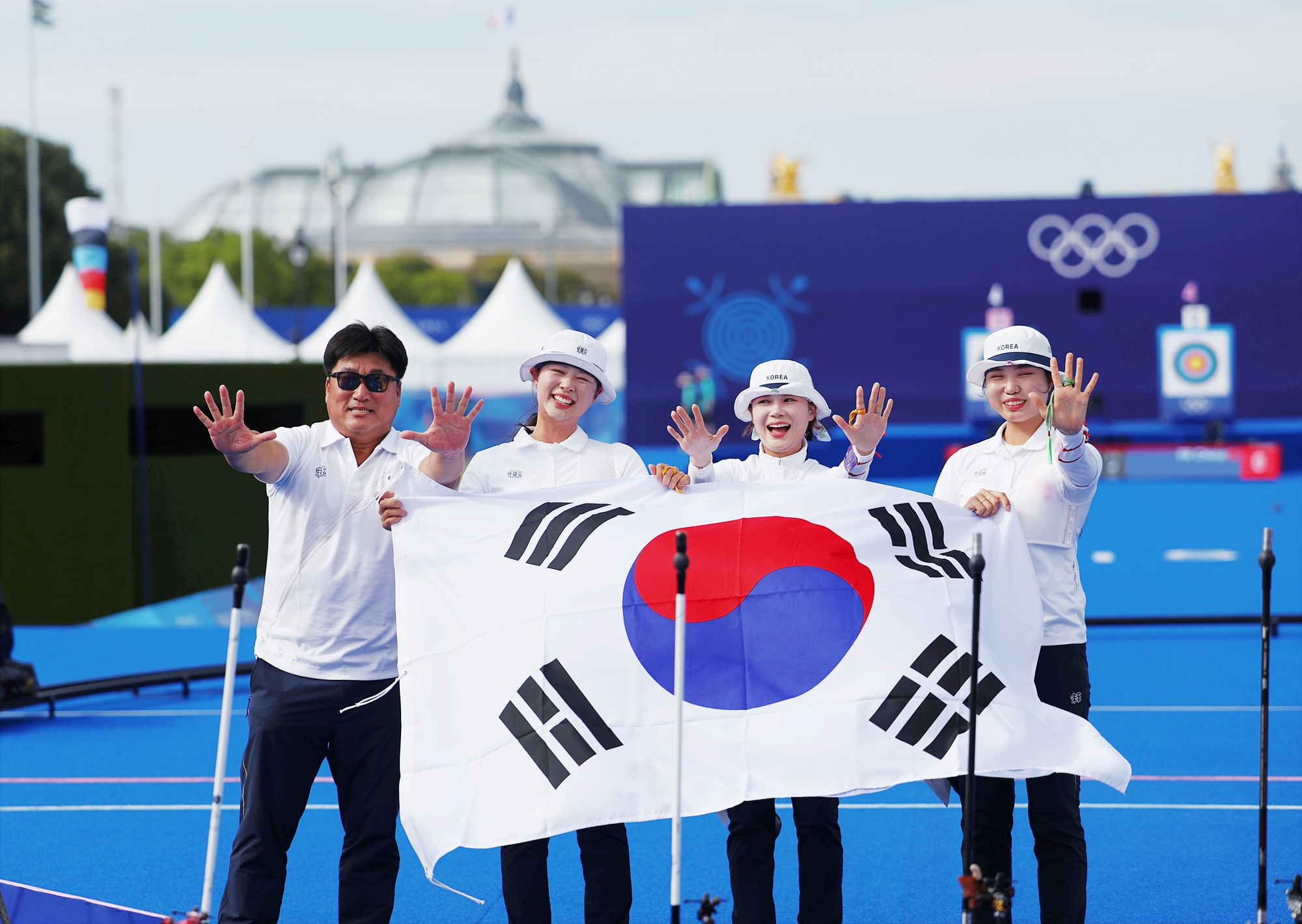 Das koreanische Bogenschießen-Damen-Team posieren am 28. Juli nach ihrem Sieg im Damen-Team-Finale im Bogenschießen bei den Olympischen Sommerspielen 2024 in Paris in der Esplanade Des Invalides. Von links: Trainer des koreanischen Bogenschießen-Damen-Teams Yang Chang-hoon, Lim sihyeon, Jeon Hunyoung und Nam Suhyeon. 