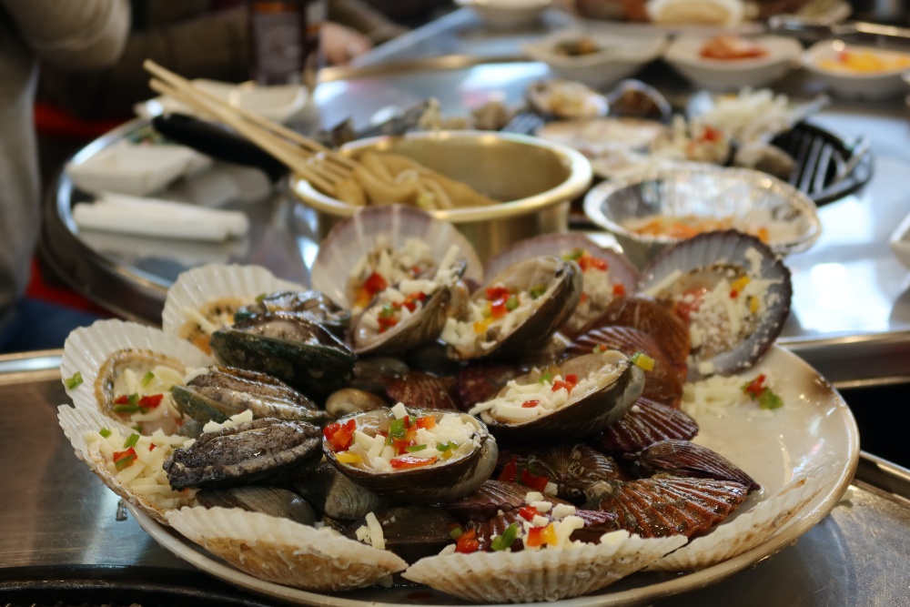 Ein koreansiches Gericht mit Muscheln, die bereit sind, auf einem Grill gegrillt zu werden