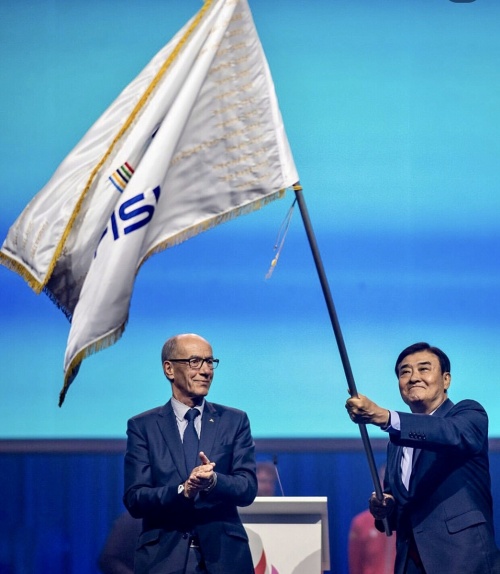 Kang Chang-hee, Präsident des Komitees, schwenkt am 27. Juli die Flagge des internationalen Hochschulsportverbandes (FISU), nachdem er sie bei der Abschlussfeier vom Rhine-Ruhr 2025 FISU in der Kraftzentrale im Landschaftspark in Duisburg, Deutschland, übernahm ⓒ Offizielles soziales Netzwerk vom FISU