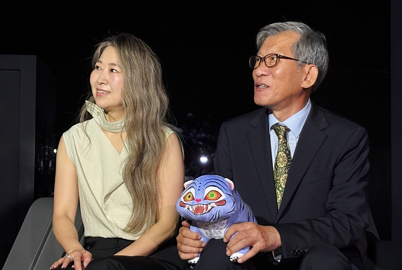 Am 21. August schauen sich Maggie Kang, Regisseurin für den Netflix-Film “KPop Demon Hunters” (links), und You Hong-june, Generaldirektor des koreanischen Nationalmuseums, im koreanischen Nationalmuseum in Yongsan-gu, Seoul, eine Medienkunst ⓒ Charles Audouin/korea.net