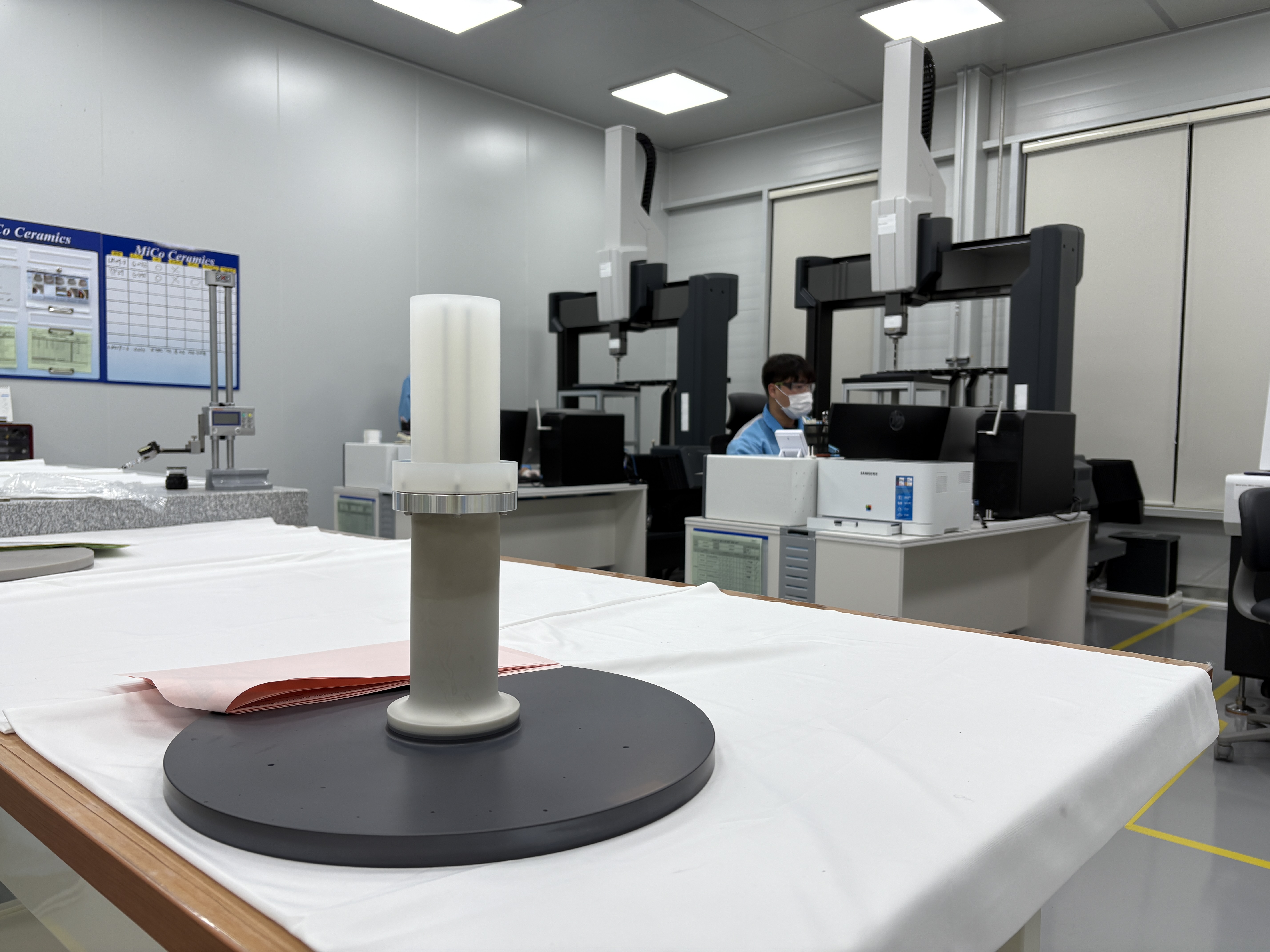 Ein Mitarbeiter vom “MiCo Ceramics” misst die Größe von Komponenten, die für Halbleiteranlagen verwendet werden 