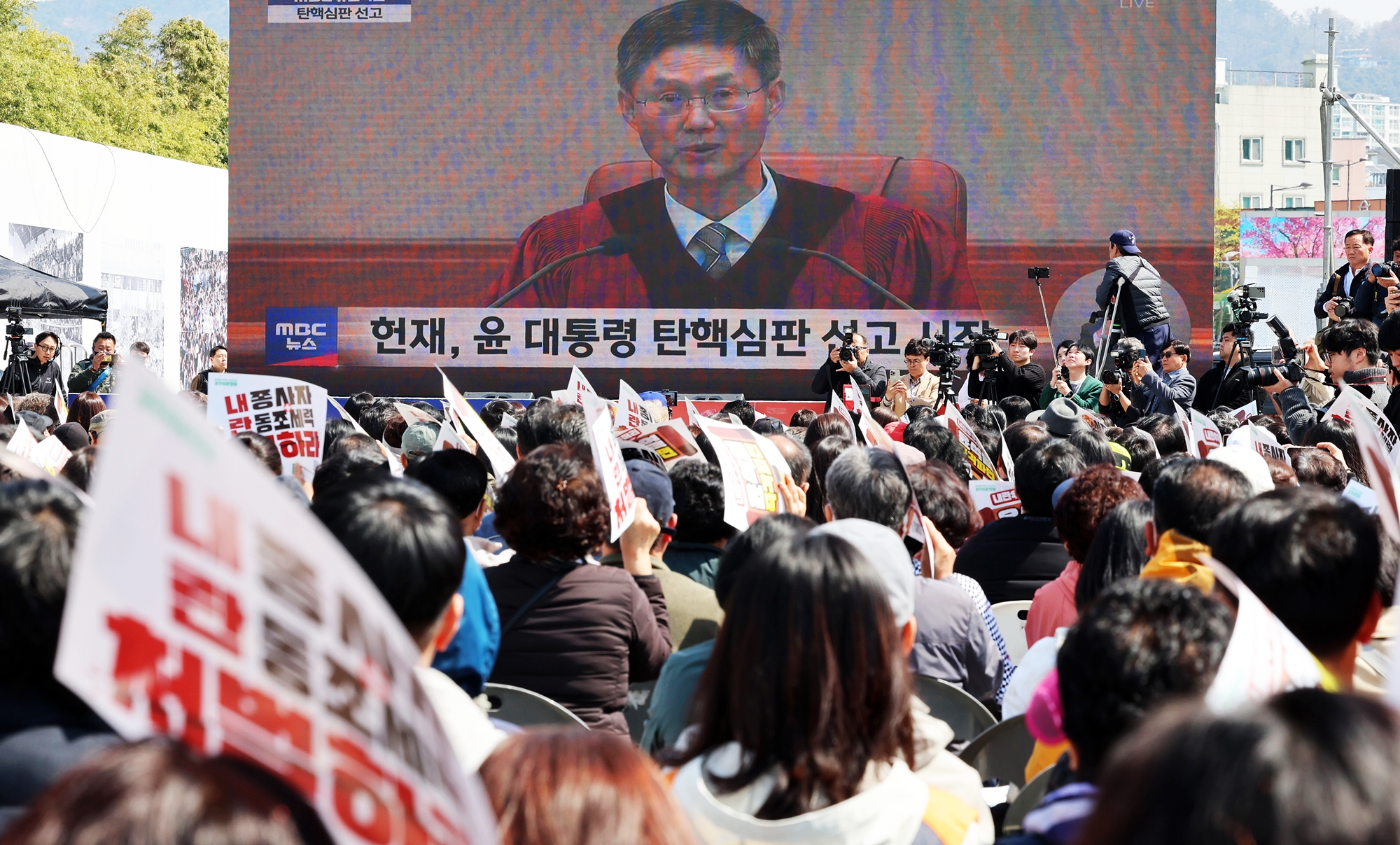 Das Verfassungsgericht nahm am 4. April den Amtsenthebungsantrag des Parlaments gegen den ehemaligen Präsidenten Yoon Suk Yeol einstimmig von acht Richtern an. Nach der Entscheidung des Verfassungsgerichts verlor Yoon sein Präsidentenamt sofort. Das Urteil wurde 112 Tage nach dem Ausruf des Kriegsrechts vom 3. Dezember letzten Jahres getroffen. Foto von Bürgern, die sich  am 4. April auf dem 5.18 Democracy Square in Dong-gu, Gwangju, die Live-Sendung der Entscheidung des Verfassungsgerichts über den Amtsenthebungsantrag gegen den suspendierten Präsidenten Yoon Suk Yeol an © Yonhap News  