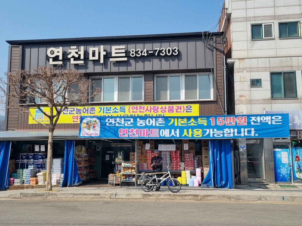 Am Eingang eines Supermarkts in Yeoncheon-gun in der Provinz Gyeonggi-do hängt ein Plakat in Bezug auf das ländliche Grundeinkommen: „Die volle Summe des ländlichen Grundeinkommens von 150.000 Won kann im Supermarkt verwendet werden” ⓒ Aisylu Akhmetzianova/korea.net
