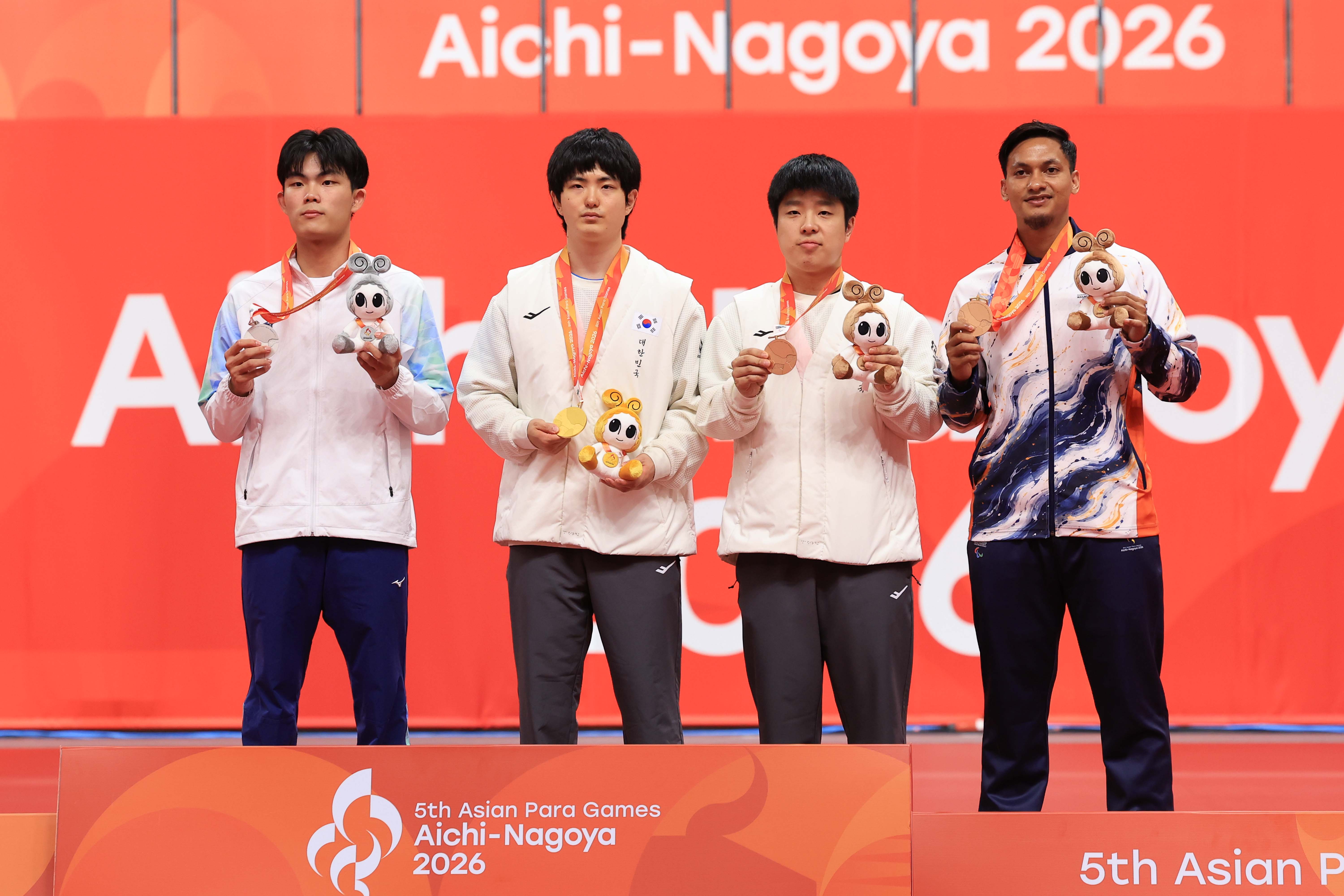 Am 20. Oktober posieren bei der Medaillenzeremonie im Herreneinzel der Klasse 11 im Tischtennis bei den Para-Asienspielen 2026 in Aichi und Nagoya in der Sky Hall Toyota in Toyota Kim Gitae mit der Goldmedaille (Zweiter von links) und Kim Bogyeon (Dritter von links) für ein Erinnerungsfoto