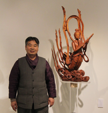 지난 8일 예술의전당에서 공개한 33점의 비천상 중 그가 가장 좋아한다는 작품, 통일신사시대 범종에 새겨진 ‘생황지비천(Bi-Cheon Playing a Redd Aerophone)’ 작품 옆에서 있는 허길량 장인. (사진: 손지애) 
