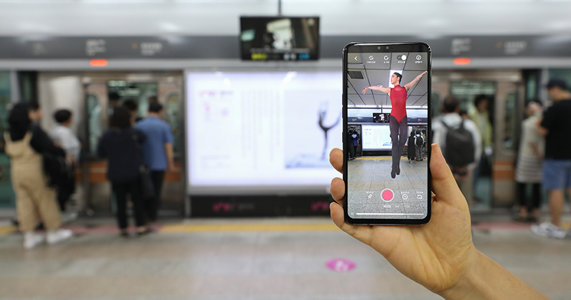 Wenn ein Smartphone auf ein Bild neben einer Plattformtür am Bahnhof <i>Gongdeok</i> gerichtet ist, ist das Werk „Listen to the Dance“ von Künstler Shin Je-hyeon zu sehen. ⓒ Kim Sunjoo/Korea.net