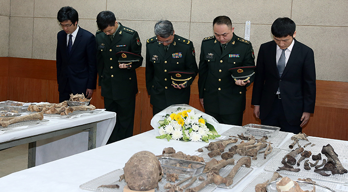 16일 한국전쟁에서 전사한 중국군 유해 입관식에서 중국군 관계자들이 헌화와 묵념을 하고 있다. 