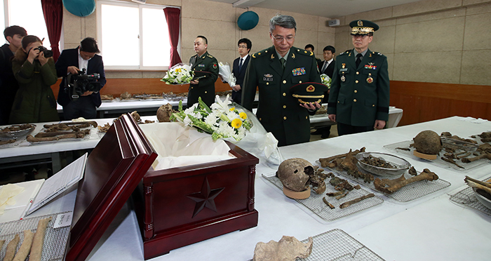 16일 경기도 파주 육군 제25사단에서 열린 중국군 유해입관식에서 주한 중국대사관 국방무관 뚜농이(杜农一, Du Nong Yi)소장이 영현들에 대해 애도를 표하고 있다. 오른쪽은 한국 국방부 군비통제차장 문상균 준장.