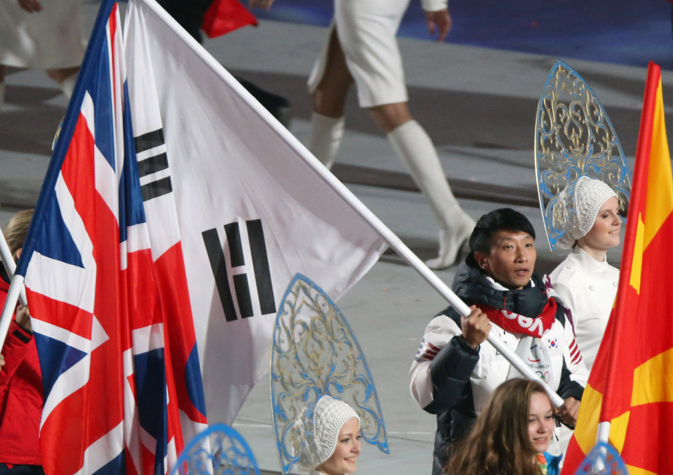 Korean speed skater Lee Kyu-hyuk, as the flag bearer representing Korea, marches into the stadium holding the Taegeukgi during the closing ceremony of the 2014 Sochi Winter Olympic Games on February 23. (photo: Yonhap News) 