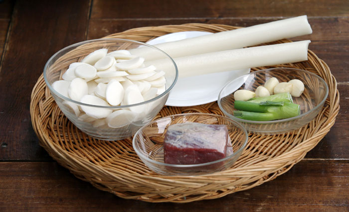The main ingredients for <i>tteokguk</i> are sliced white rice cake, beef, either brisket or shank, green onions, garlic, black pepper, an egg, red chili pepper, salt and soy sauce.