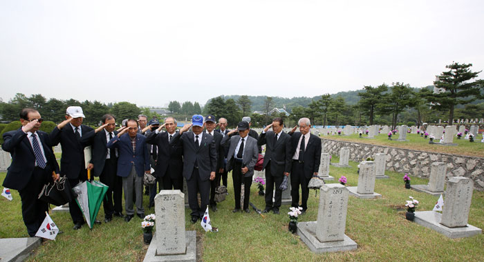 동기의 묘를 찾아 비석을 닦고 경례하는 월남전 참전용사들