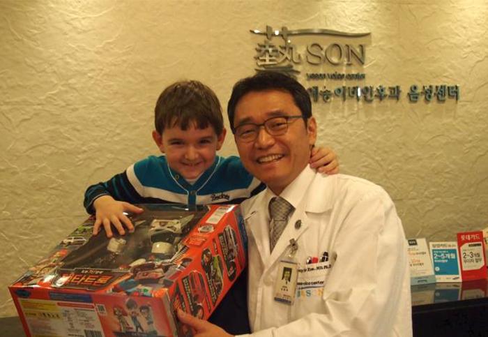 A Russian boy poses for a photo after undergoing surgery on his larynx and respiratory tract in Korea last year.