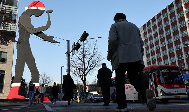 Statue „Hammer-Mann“ mit Hut und Socken des Weihnachtsmanns