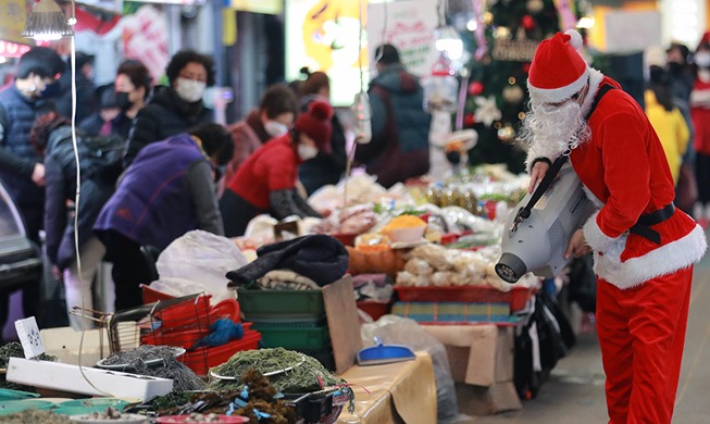 Weihnachtsmann führt Desinfektion auf dem Markt durch