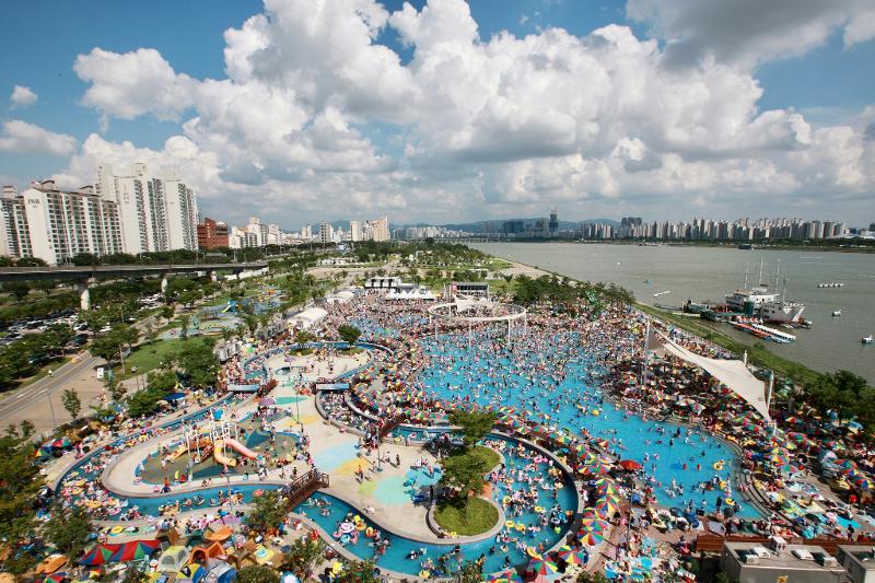 Die Hangang-Freibäder und die Parkgelände mit Schwimmbecken werden zum ersten Mal seit drei Jahren wiedereröffnet, seit es aufgrund der Pandemie geschlossen wurde. Abgebildet ist das Freibad Ttukseom, das über „Aqua-Ring“, einen kreisförmigen Wasserfall, unter dem Schwimmer stehen können, und einen Lazy River, in dem Schwimmer in fließendem Wasser treiben können, verfügt.