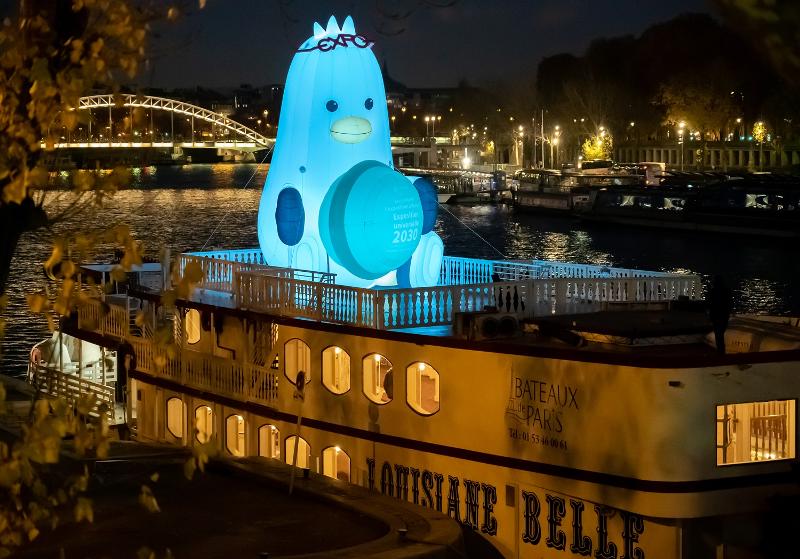 „Boogi“, ein 8 Meter hohes Maskottchen der Busan Expo 2030, trägt eine „EXPO“-Brille auf dem Kopf und hält eine Makrone in der Hand, um für seine Bewerbung um die Austragung der Weltausstellung zu werben