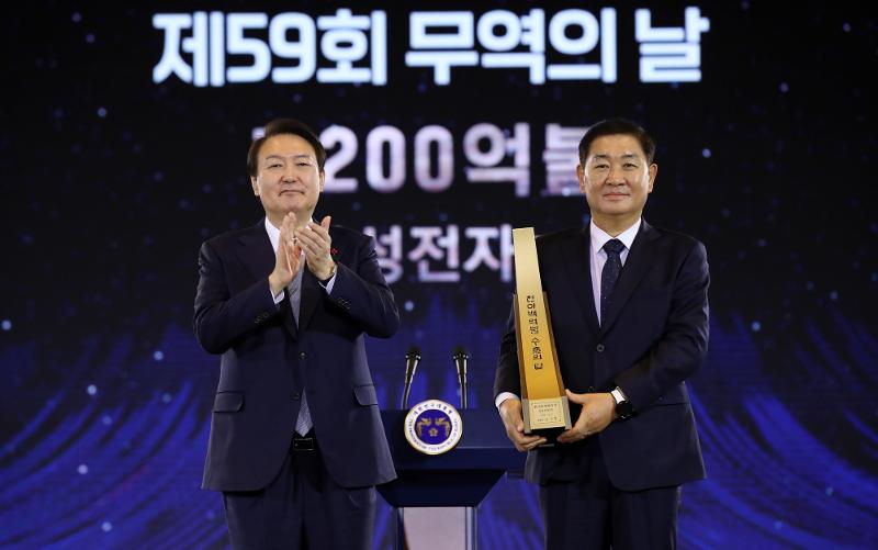 Präsident Yoon Suk Yeol posiert am 5. Dezember 2022 für ein Foto mit dem stellvertretenden Vorsitzenden von Samsung Electronics, Han Jong-hee, nachdem er ihm während einer Zeremonie anlässlich des Handelstages des Landes in der COEX-Mall in Seoul eine Trophäe für die Erzielung von Exporten im Wert von 120 Milliarden US-Dollar überreicht hatte. ⓒ Yonhap News