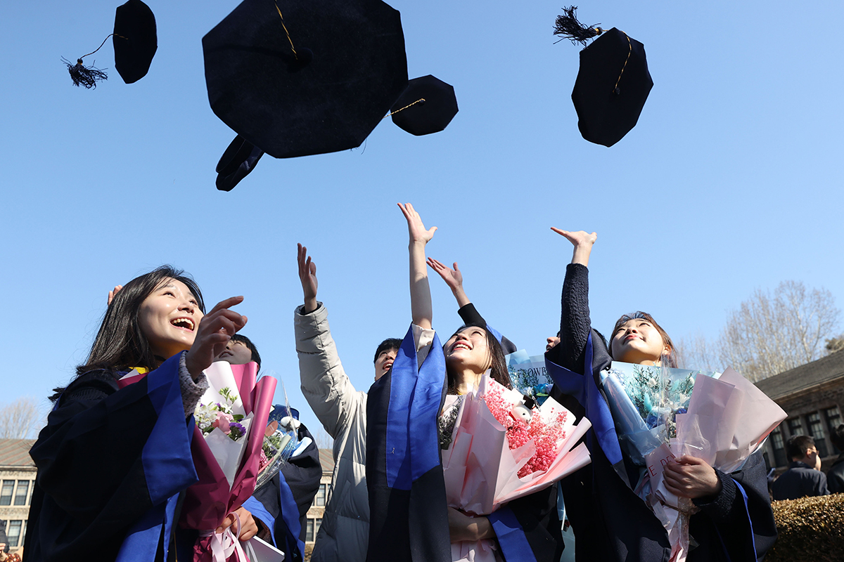 Am 24. Februar werfen Absolventen vor der Abschlussfeier an der Yonsei-Universität in Seodaemun-gu, Seoul, ihre Doktorhüte in die Luft.