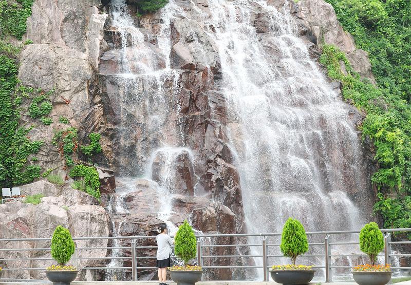 Am 7. Juli kühlt sich ein Bürger vor einem Wasserfall im Yongma Waterfall Park in Jungnang-gu, Seoul, ab. In diesem Jahr fällt Soseo, der Tag der geringen Hitze, auf den 7. Juli.'