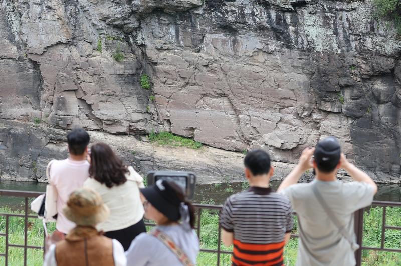 ﻿Besucher mit Teleskop vom Bangudae Petroglyphen-Aussichtspunkt am 13. Juli, in Daegok-ri, Ulju-gun, Ulsan. Am 12. Juli, wurden die „Bangucheon Petroglyphs“, bestehend aus den „Bangudae-Petroglyphen von Ulju Daegok-ri“ und den „Inschriften und Petroglyphen von Ulju Cheonjeon-ri“, zum UNESCO-Weltkulturerbe erklärt ⓒ Yonhap News