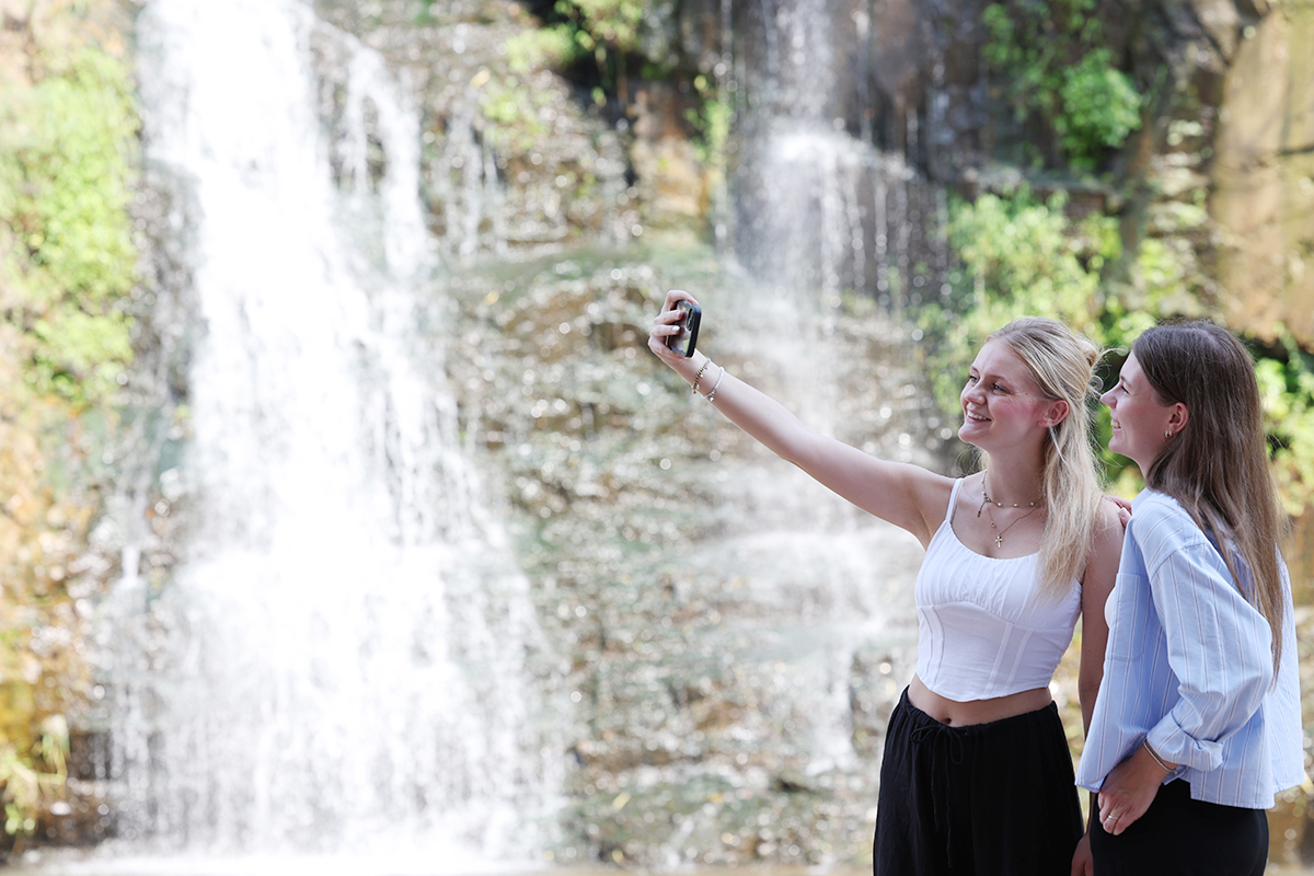 Am 21. August, an dem eine Hitzewarnung für das ganze Land herausgegeben wurde, posieren ausländische Touristen am Hongjecheon-Wasserfall in Seodaemun-gu, Seoul, für Fotos.