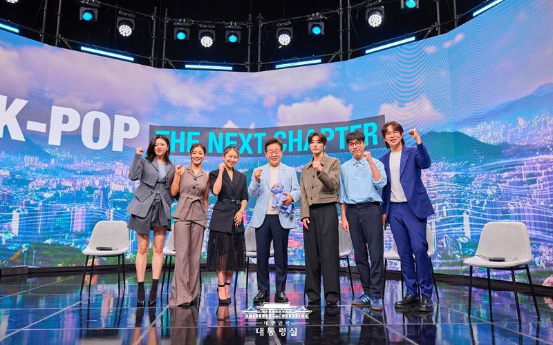 Präsident Lee Jae Myung macht am 20. August auf Sendung “K-Pop: The Next Chapter” von Arirang TV, einem koreanischen Fernsehsender, ein Erinnerungsfoto mit Teilnehmern. Von links: Jeongyeon, Mitglied von TWICE, Jihyo, Mitglied von TWICE, Maggie Kang, Regisseurin von der Netflix-Animation KPop Demon Hunters, Präsident Lee, R.Tee, Musikproduzent, und Kritiker Kim Young-dae und Moderator Jang Sung-kyu