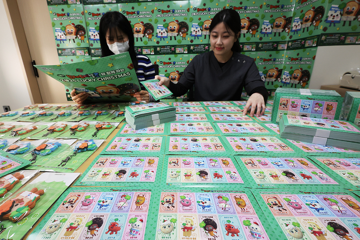 Am 24. November arbeiten zwei Mitarbeiterinnen der Korean National Tuberculosis Association von Gyeonggi-do in Paldal-gu, Suwon, die Bögen mit Weihnachtsmarken. In diesem Jahr wurden sie in Zusammenarbeit mit Charakteren aus dem Animationsfilm 