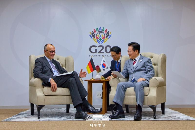 Präsident Lee Jae Myung (rechts) und Friedrich Merz, der deutsche Bundeskanzler, treffen sich am 22. November im Nasrec Expo Centre in Johannesburg, Südafrika, für das Gipfeltreffen 