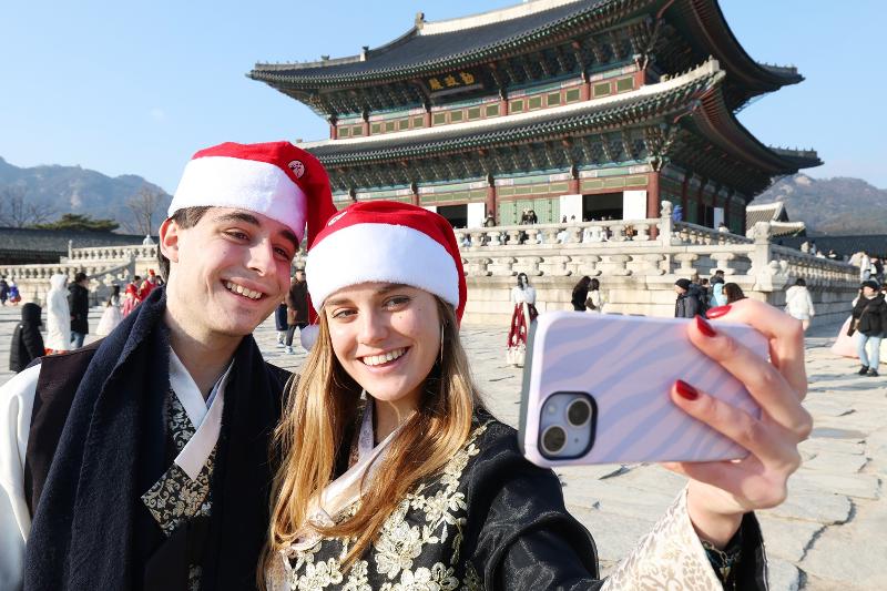 Am 23. Dezember letzten Jahres machen ausländische Touristen vor dem Gyeongbokgung-Palast ein Erinnerungsfoto ⓒ Lee Jeong Woo/korea.net