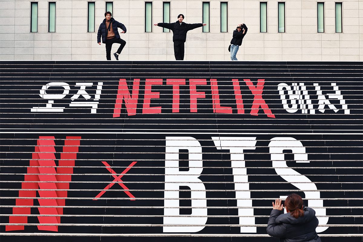 Am 11. M&auml;rz machen ausl&auml;ndische Touristen ein Erinnerungsfoto mit dem Werbeplakat f&uuml;r das Konzert der K-Pop-Boygruppe BTS auf der Treppe des Sejong Center for the Performing Arts.