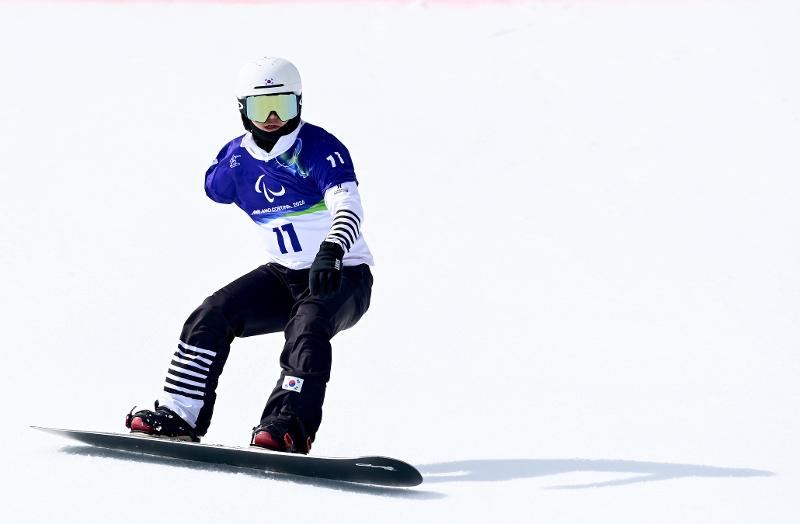Am 13. M&auml;rz setzt der koreanische Para-Snowboarder Lee Chungmin im Banked Slalom der Frauen (SB-UL) bei den Paralympics seinen K&ouml;rper aufs Board und f&auml;hrt die Piste hinter ⓒ Koreanisches Paralympisches Komitee 