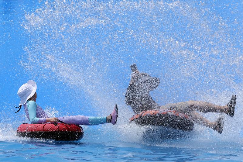 Am 21. Juli genie&szlig;en Besucher im Kinder-Wasserpark des Samnak Ecological Park in Busan das Rutschen mit Schwimmreifen.